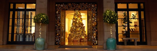 Christmas tree decorated in gold showing through the open double doors of the hotel's entrance