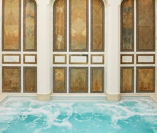 A large immersion pool at a spa with mosaic walls