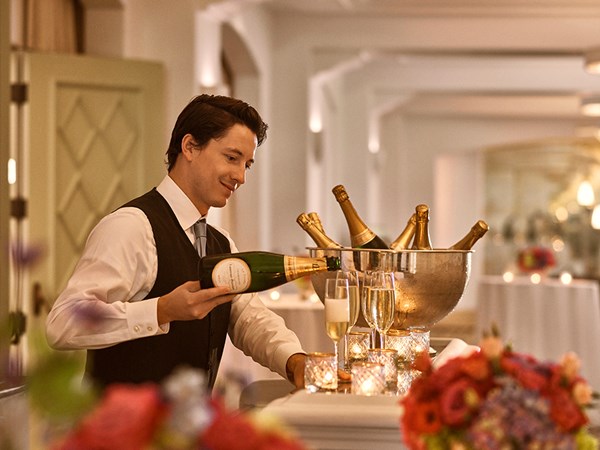 Barman serving champagne from a bucket of bottles in the ballroom