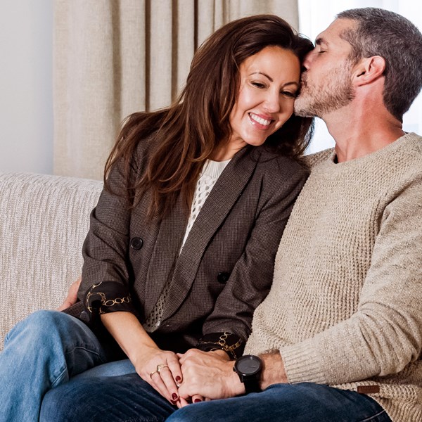 a romantic couple sitting on the couch within a hotel suite