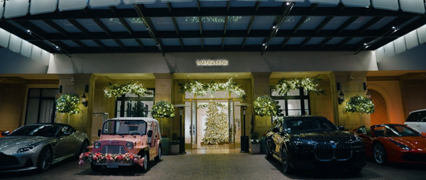 front entrance of a hotel with christmas decor and cars